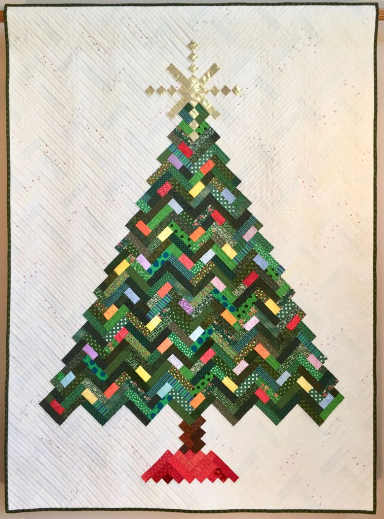 Photo of a quilt with a Christmas tree design.